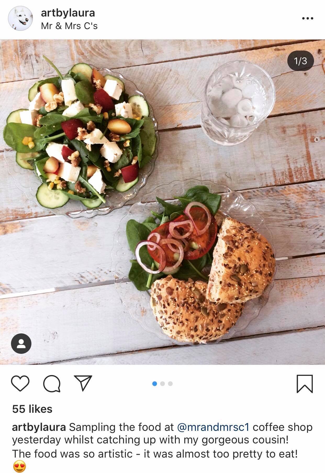 An instagram post of a sandwich and salad bought at the cafe by user @artbylaura.